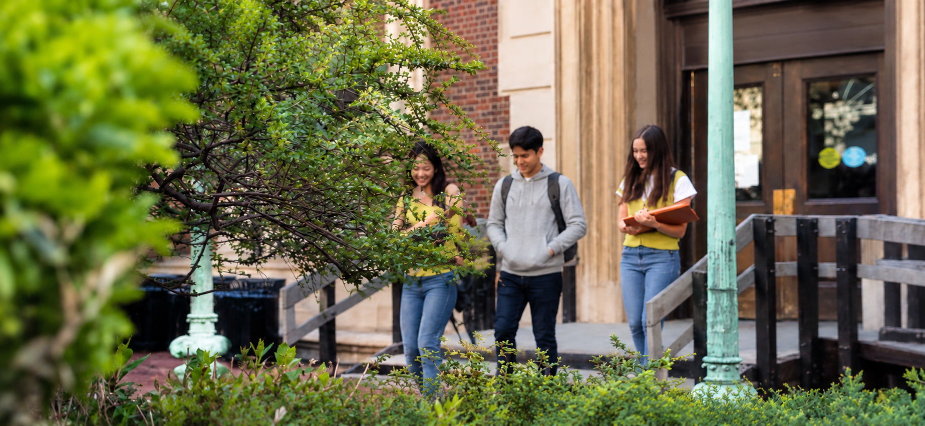 Students walking from a university building into a garden